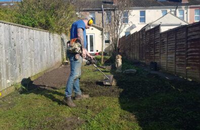 Lawn first.  Level out the worst of the lumps with a cultivator